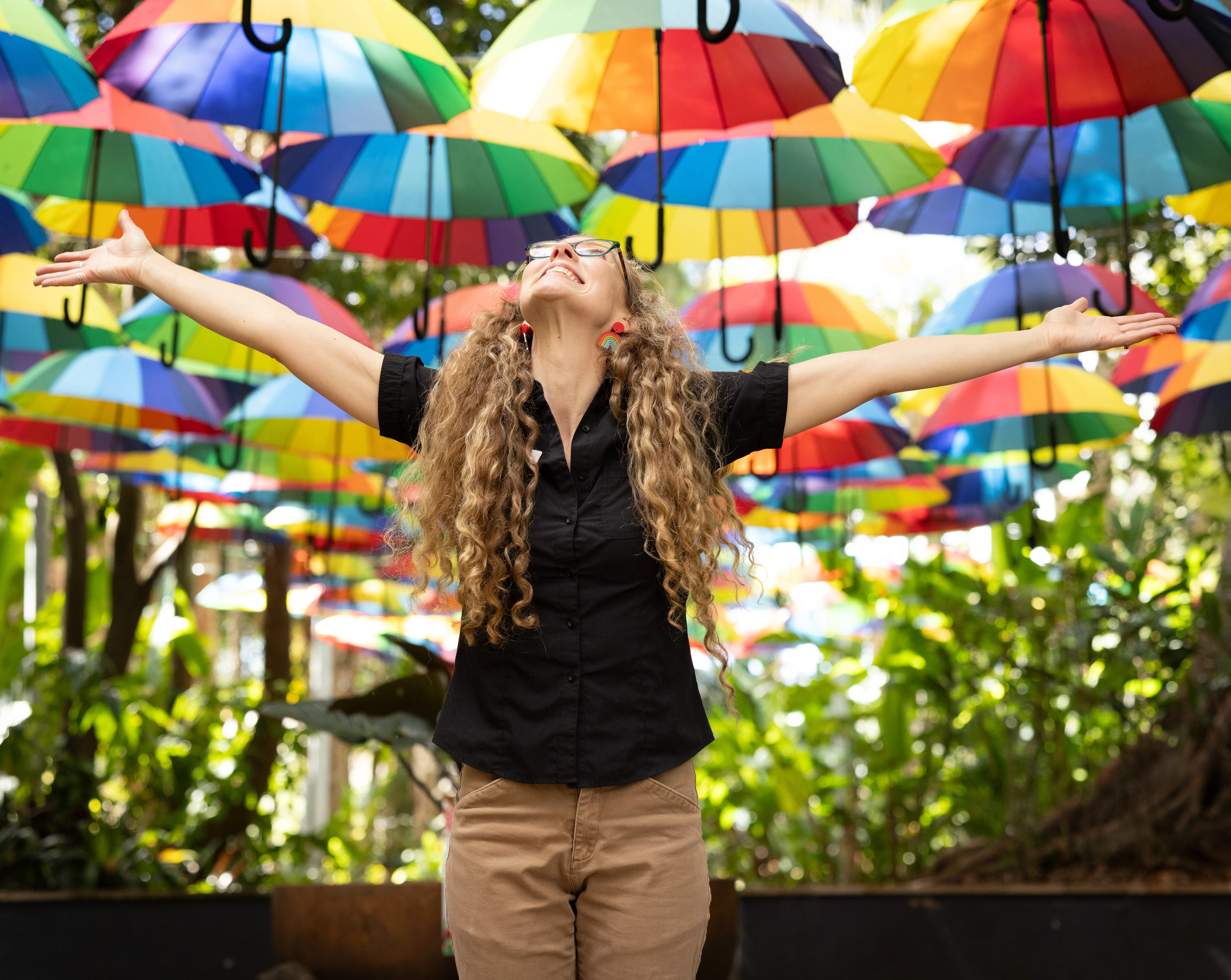 Smiling woman holds colourful inflatable flowers