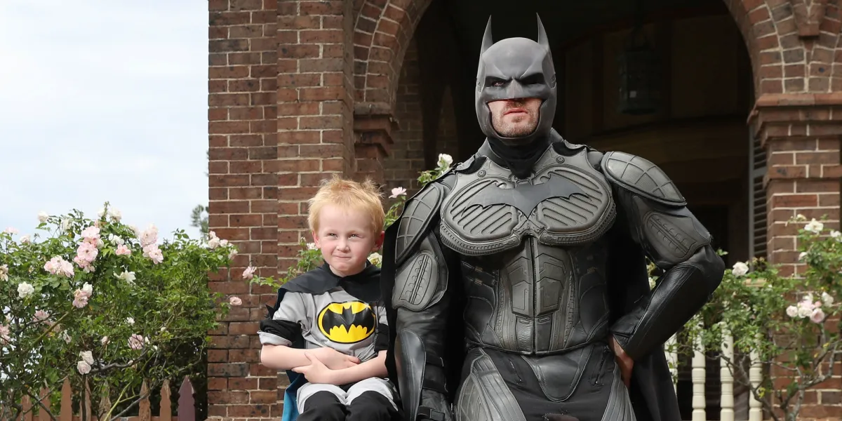 Make-A-Wish kid Rory sits next to batman on wish day