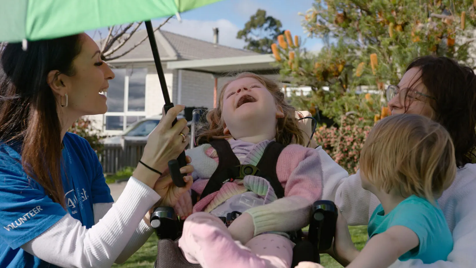 Smiling wish child is under umbrella with family