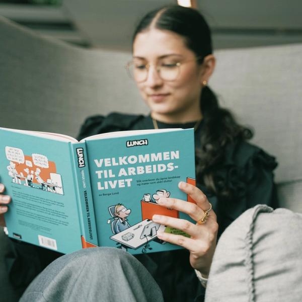 Ung kvinne leser tegneserie med tittel «Velkommen til arbeidslivet»