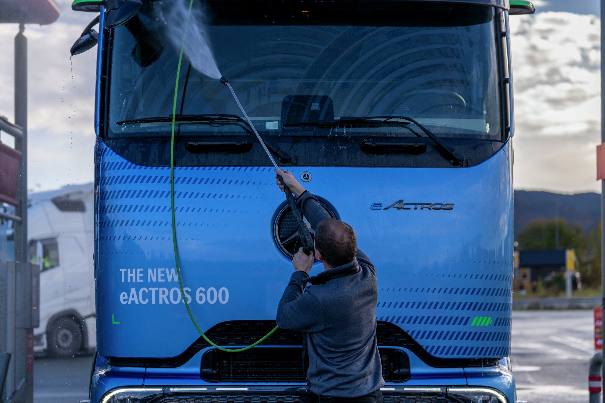 Mann spyler fronten på en lastebil.
