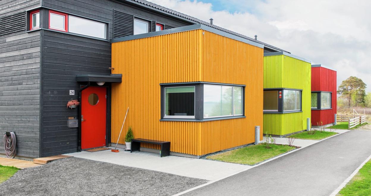 Fargerikt rekkehus med ryddig fasade