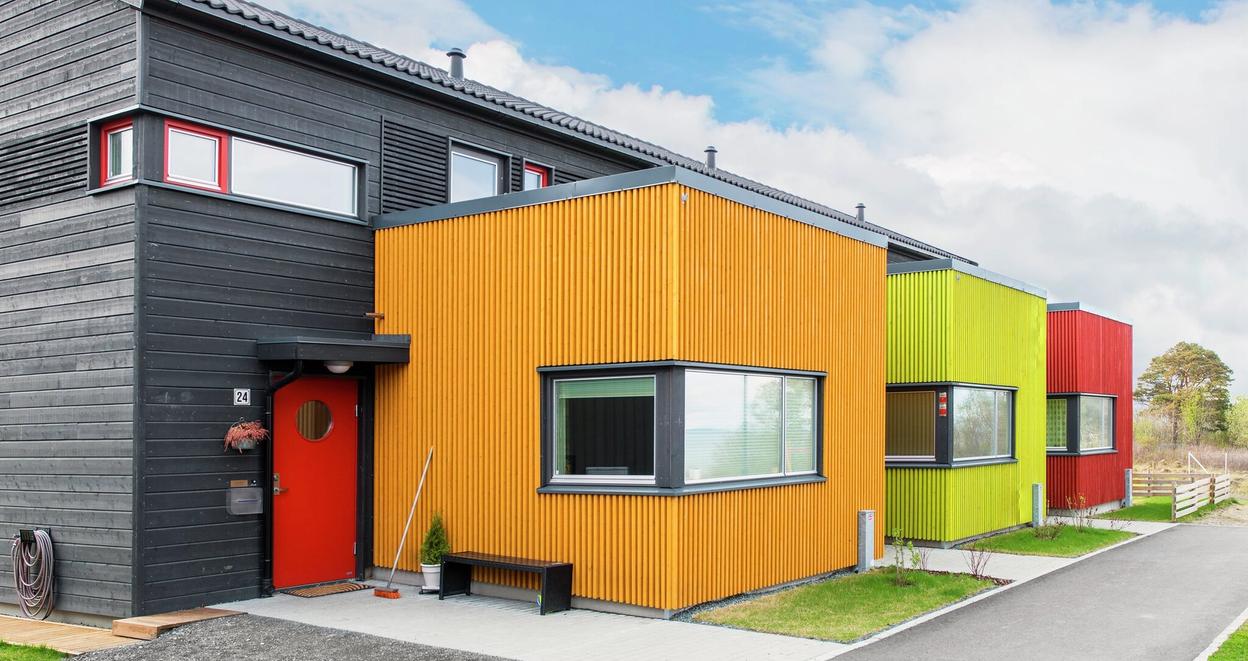 Fargerikt rekkehus med ryddig fasade