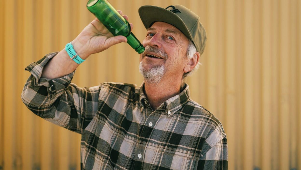 Mann later som han drikker fra en flaske som er tom.