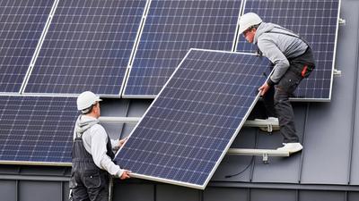 Håndverkere installerer solcelleanlegg på boligtak