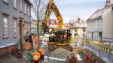 To elektriske gravemaskiner står utstilt ved en messe