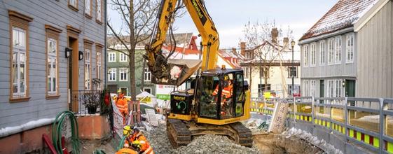 To elektriske gravemaskiner står utstilt ved en messe