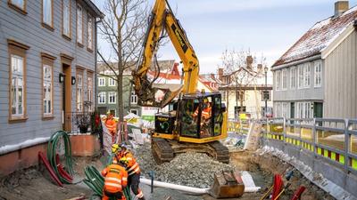 To elektriske gravemaskiner står utstilt ved en messe