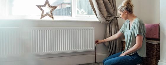 Boligeier justerer innstilling på radiator