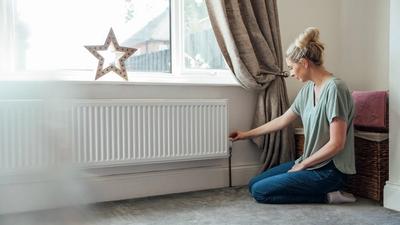 Boligeier justerer innstilling på radiator