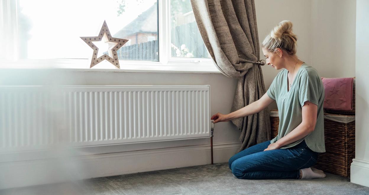 Boligeier justerer innstilling på radiator