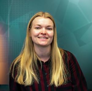 Portrett av ung kvinne foran en blå glassvegg