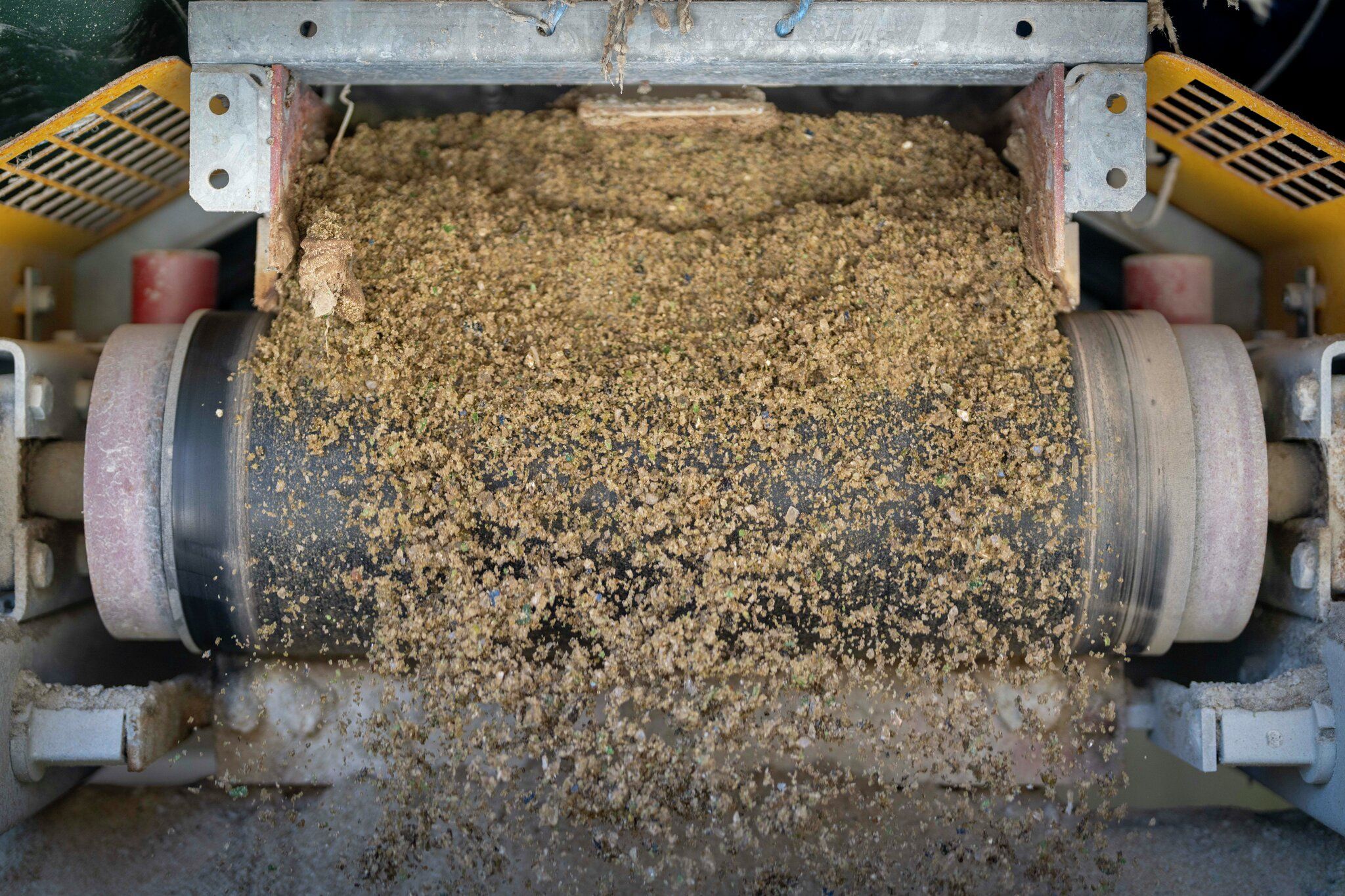 Glass og grus ut av en maskin.