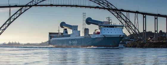 Skip med senkede rotorseil passerer under bro