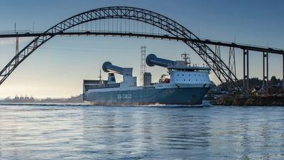 Skip med senkede rotorseil passerer under bro