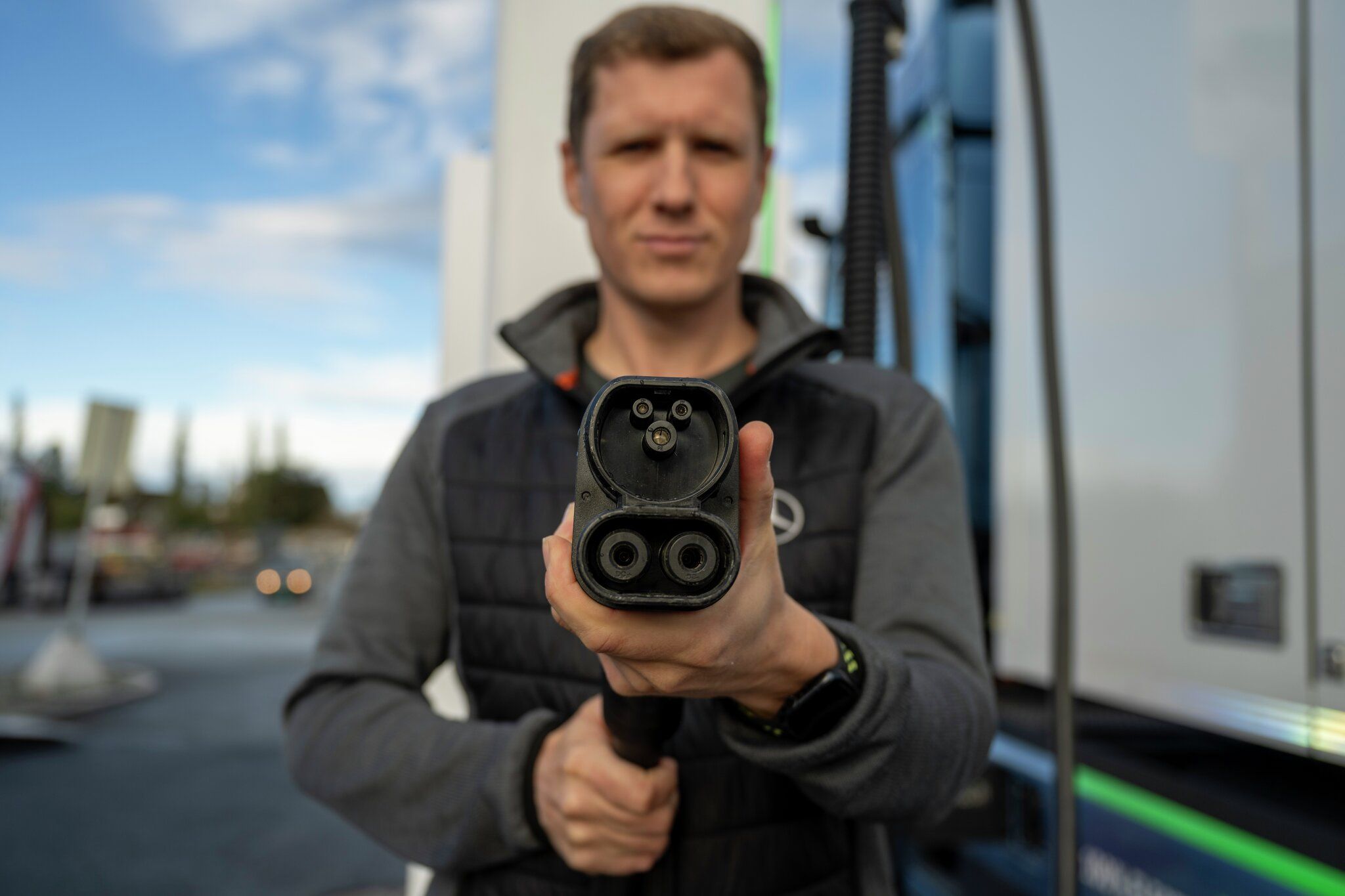 mann holder ladekabel i hånden.