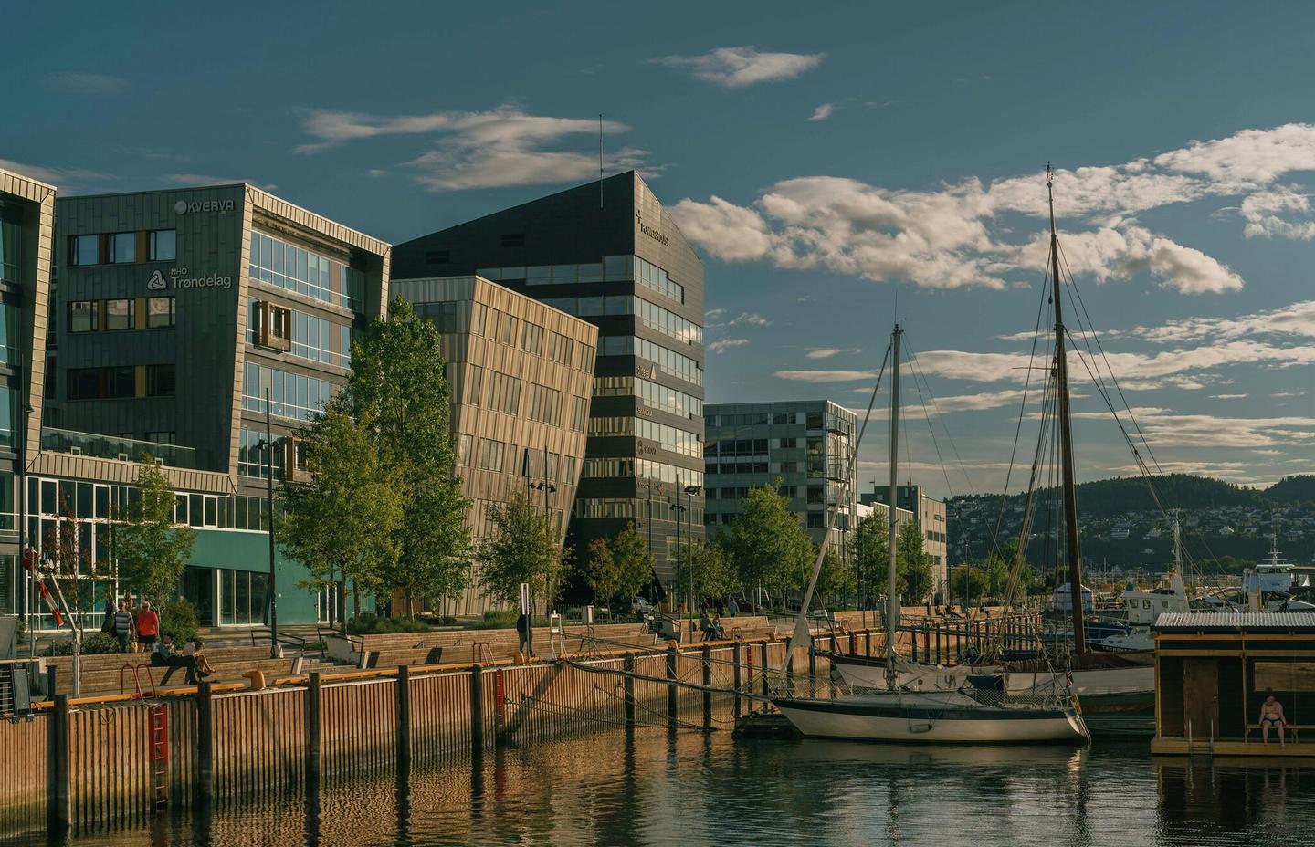 Tre store bygg ved ei kai.