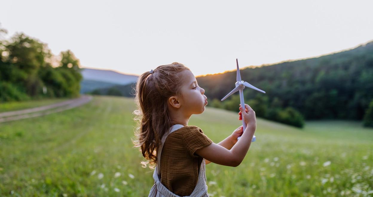 Et barn holder en vindmølleleke