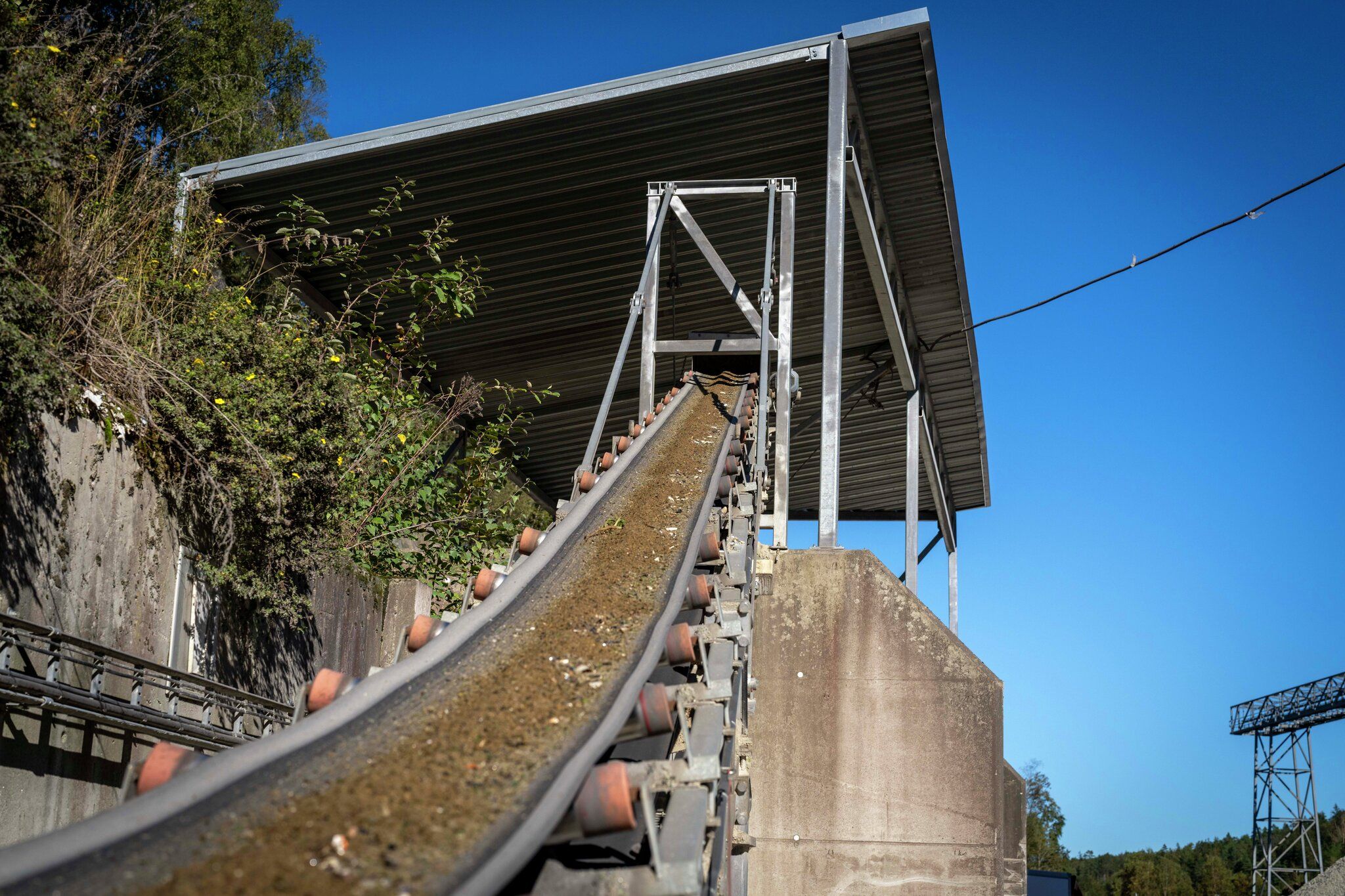 Grus og glass på transportbånd.