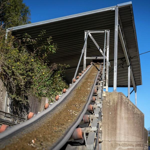 Grus og glass på transportbånd.