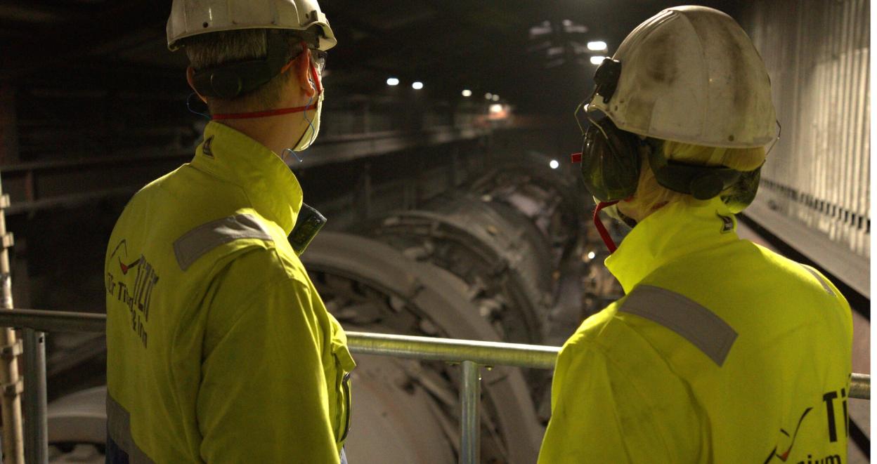 Industriarbeidere ser ned på rør