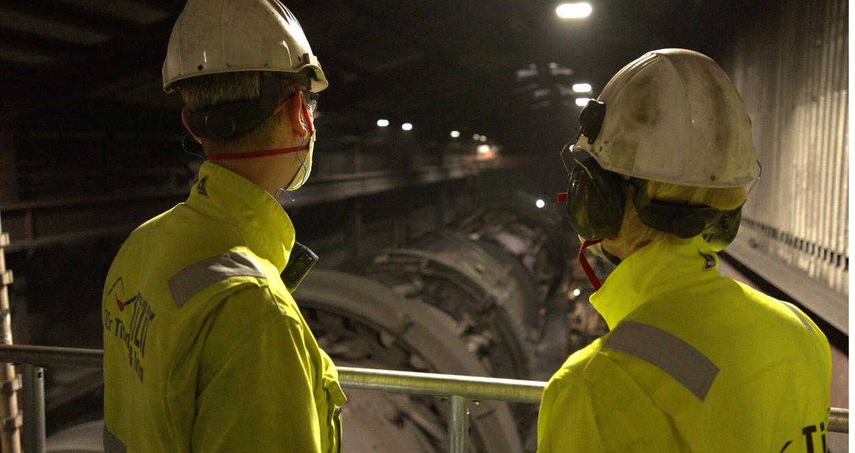 Industriarbeidere ser ned på rør