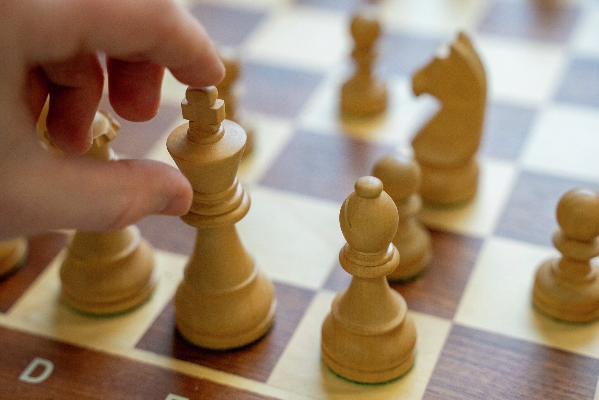 En hånd flytter den hvite kongen på et sjakkbrett