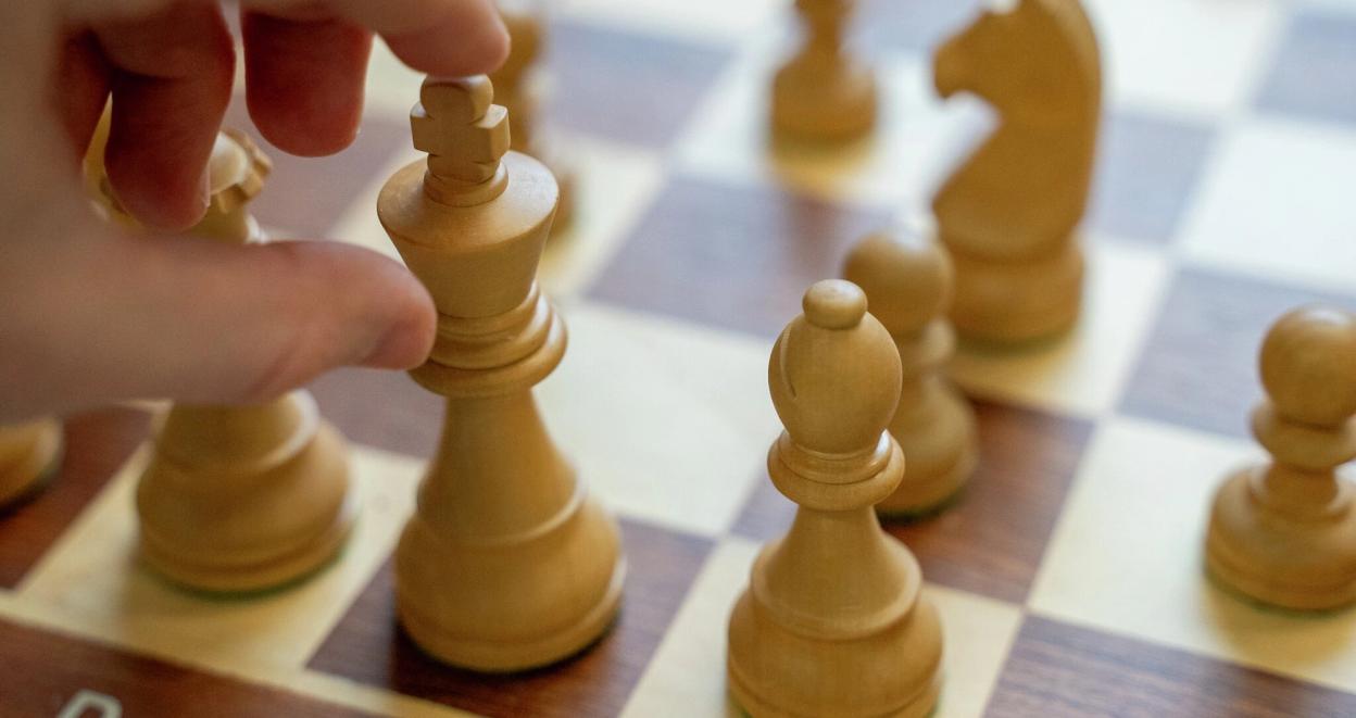 En hånd flytter den hvite kongen på et sjakkbrett