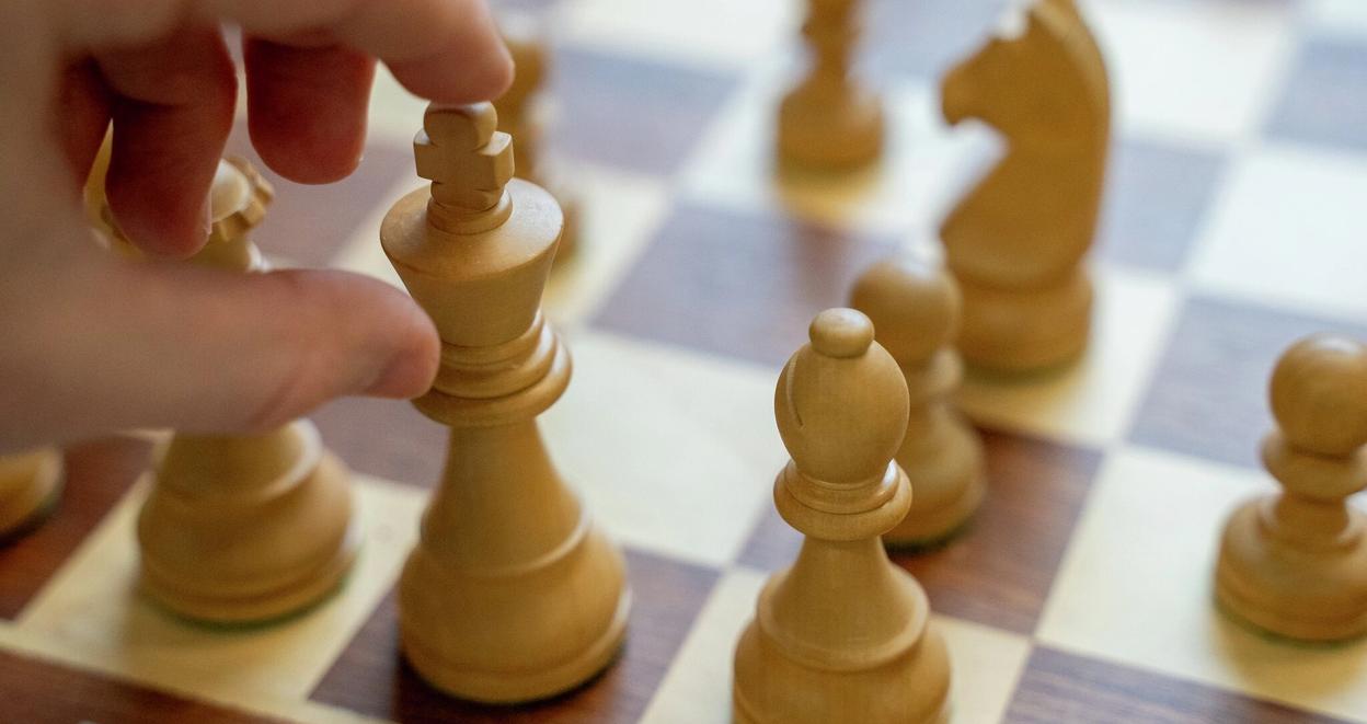 En hånd flytter den hvite kongen på et sjakkbrett