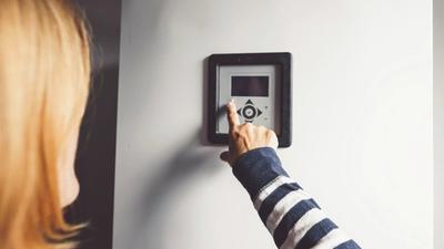 Boligeier justerer innstilling på smart varmtvannsbereder