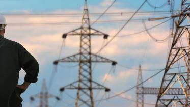 Ansatt står og skuer ut over kraftledninger