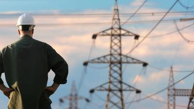 Ansatt står og skuer ut over kraftledninger
