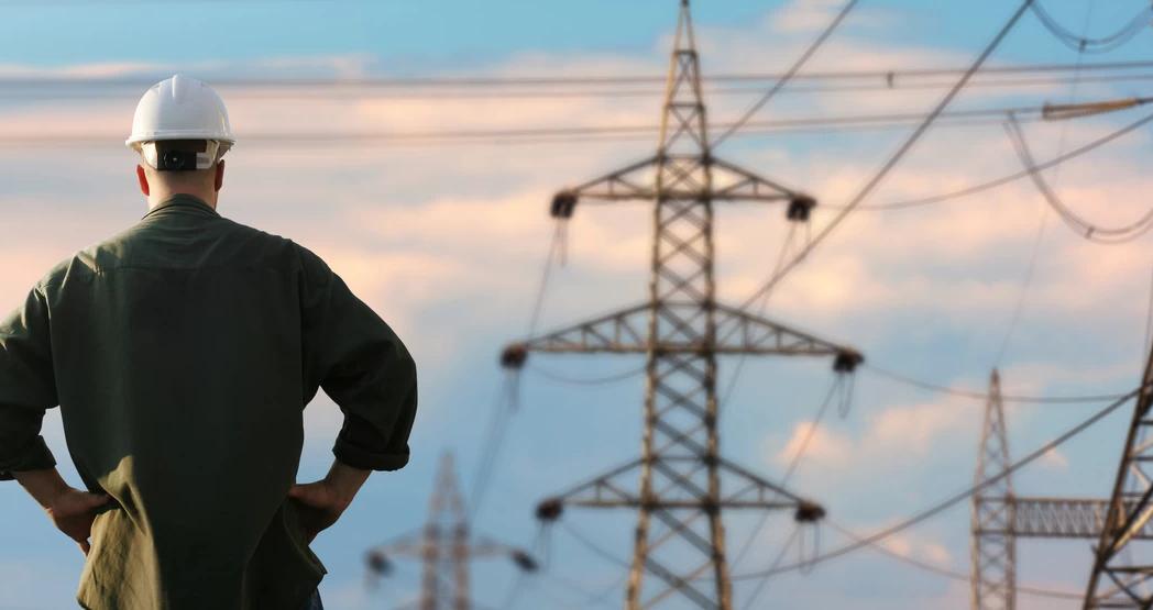 Ansatt står og skuer ut over kraftledninger