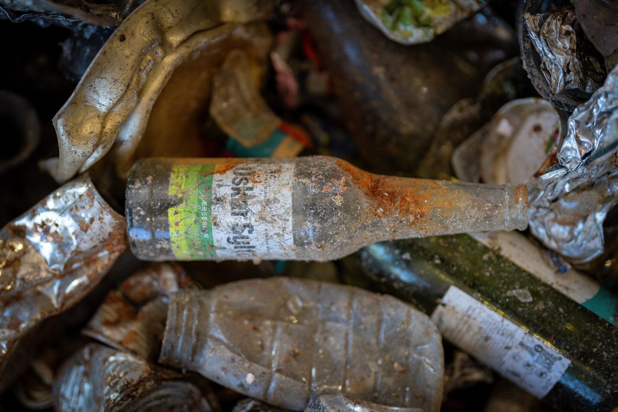 En brusflaske på søppeldynge.