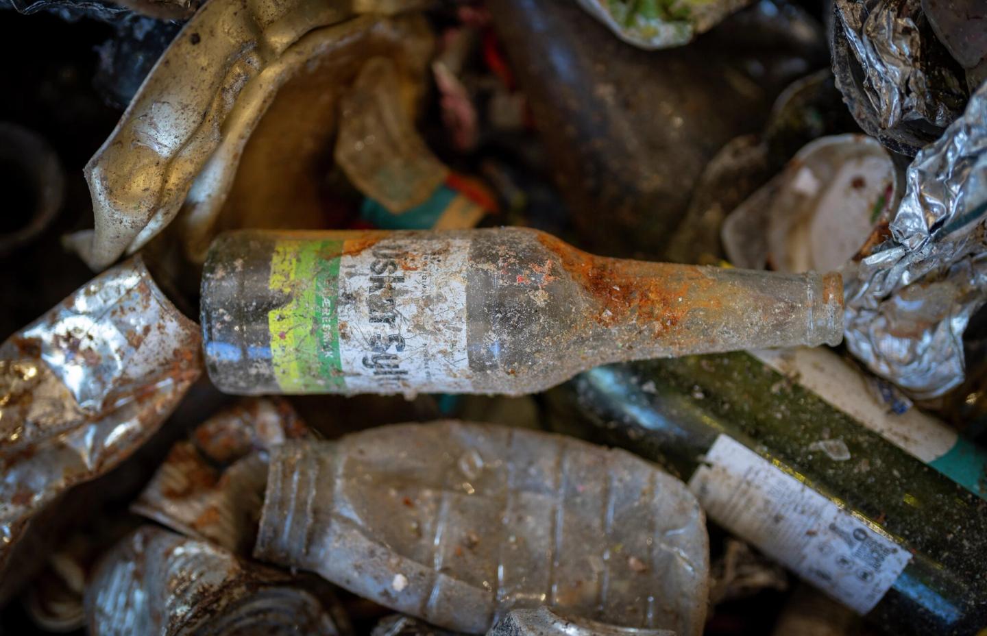 En brusflaske på søppeldynge.