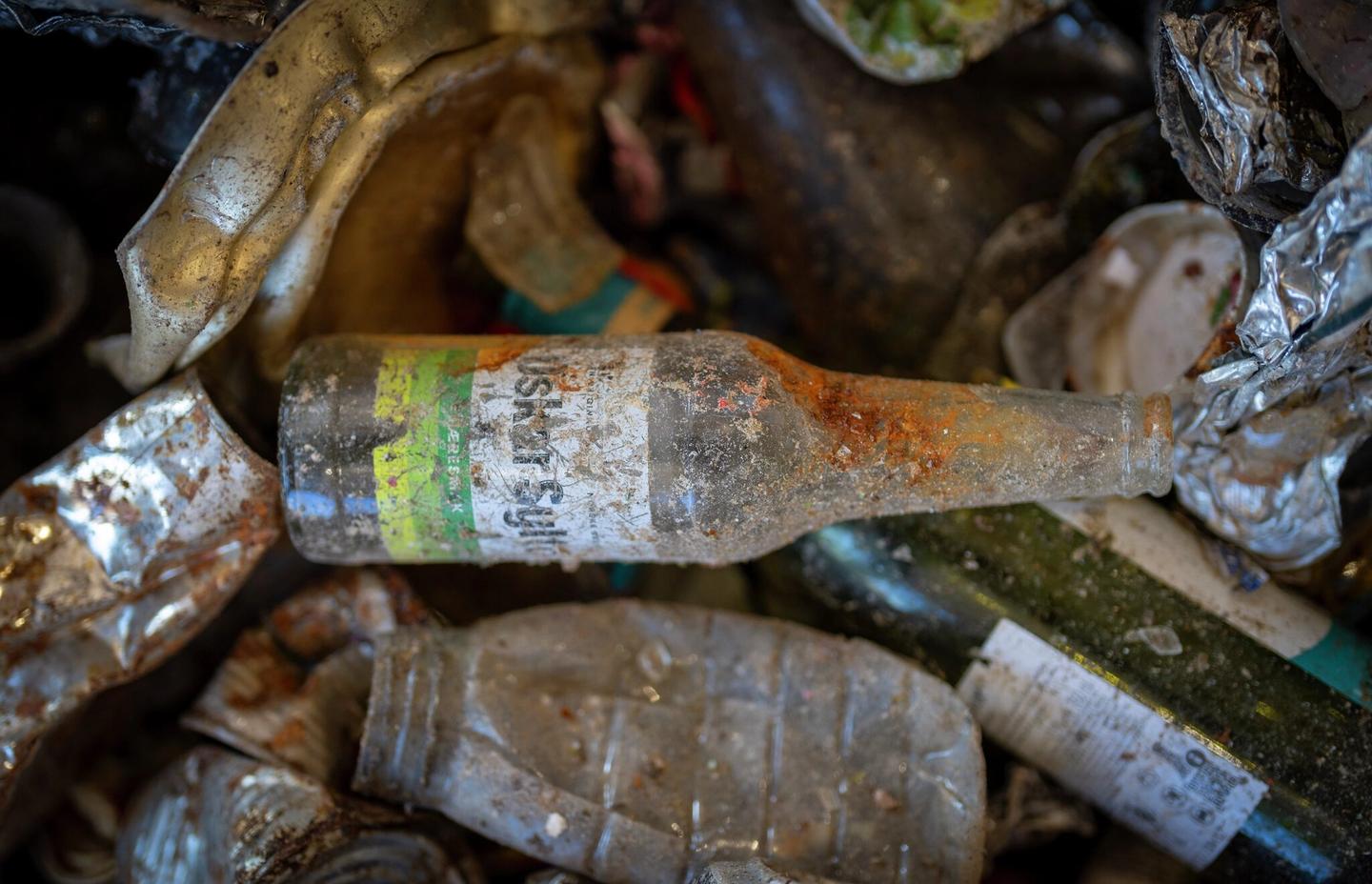 En brusflaske på søppeldynge.