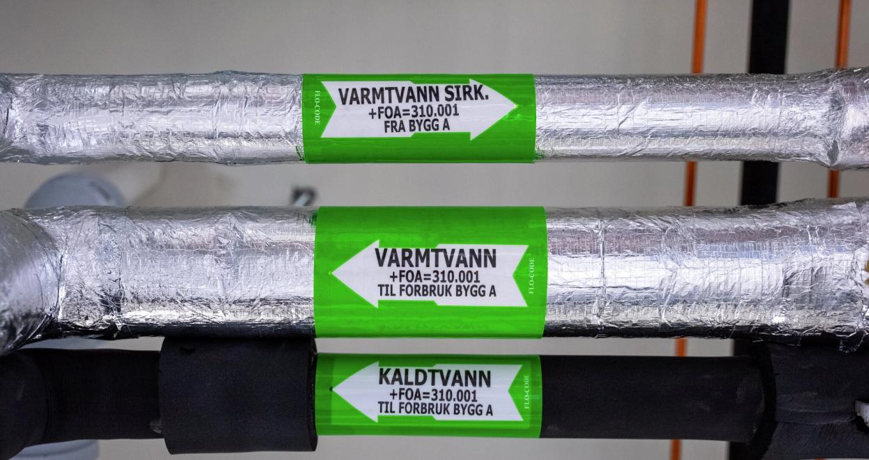 Rør merket med "varmtvann" og "kaldtvann"