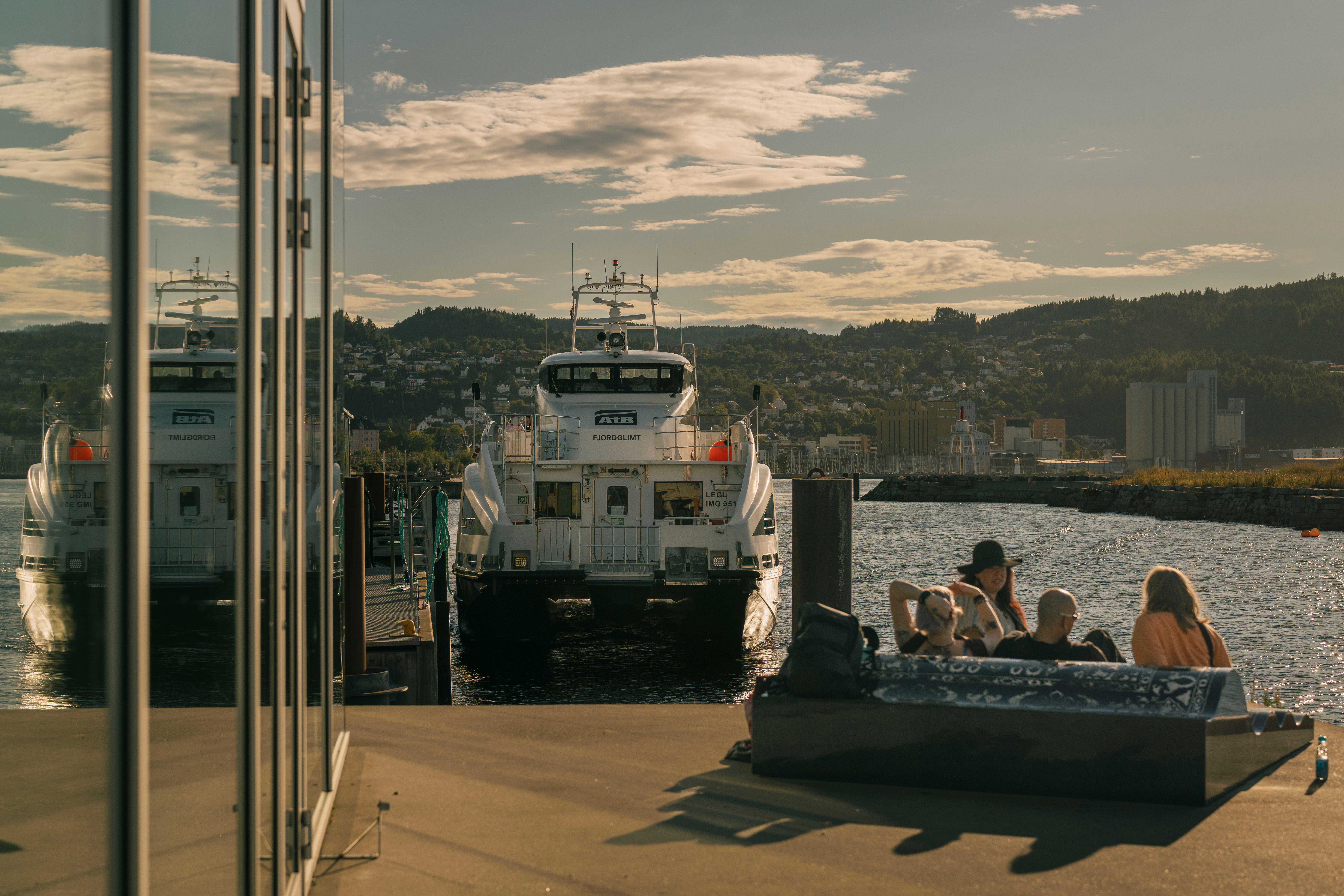 En gruppe venner sitter på ferjeleiet en varm sommerdag 