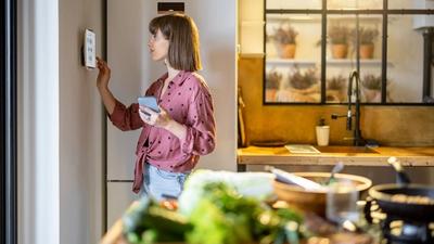 Boligeier som justerer innstilling på energistyringssystem