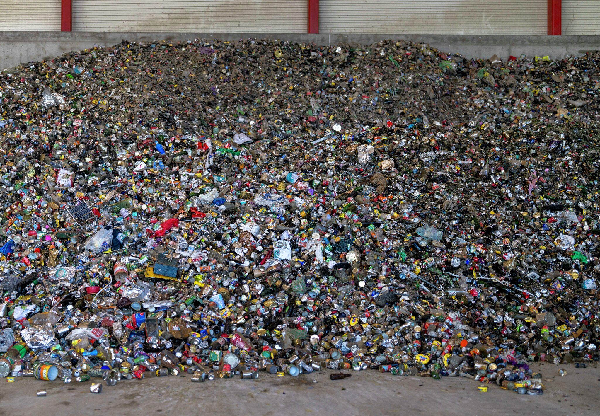 Hermetikk og glass om en annen i en stor søppelhaug.
