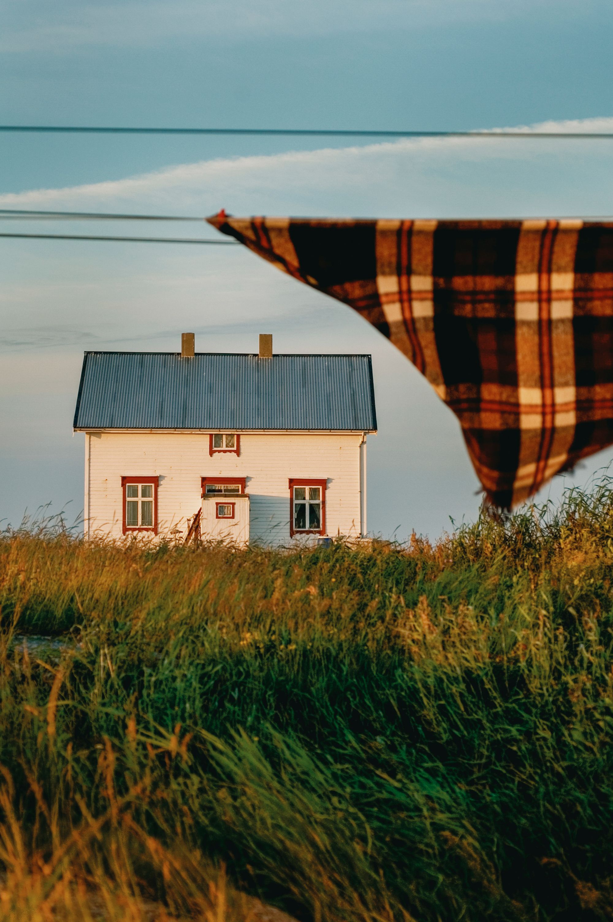 Et hvitt norsk kysthus en varm sommerkveld 