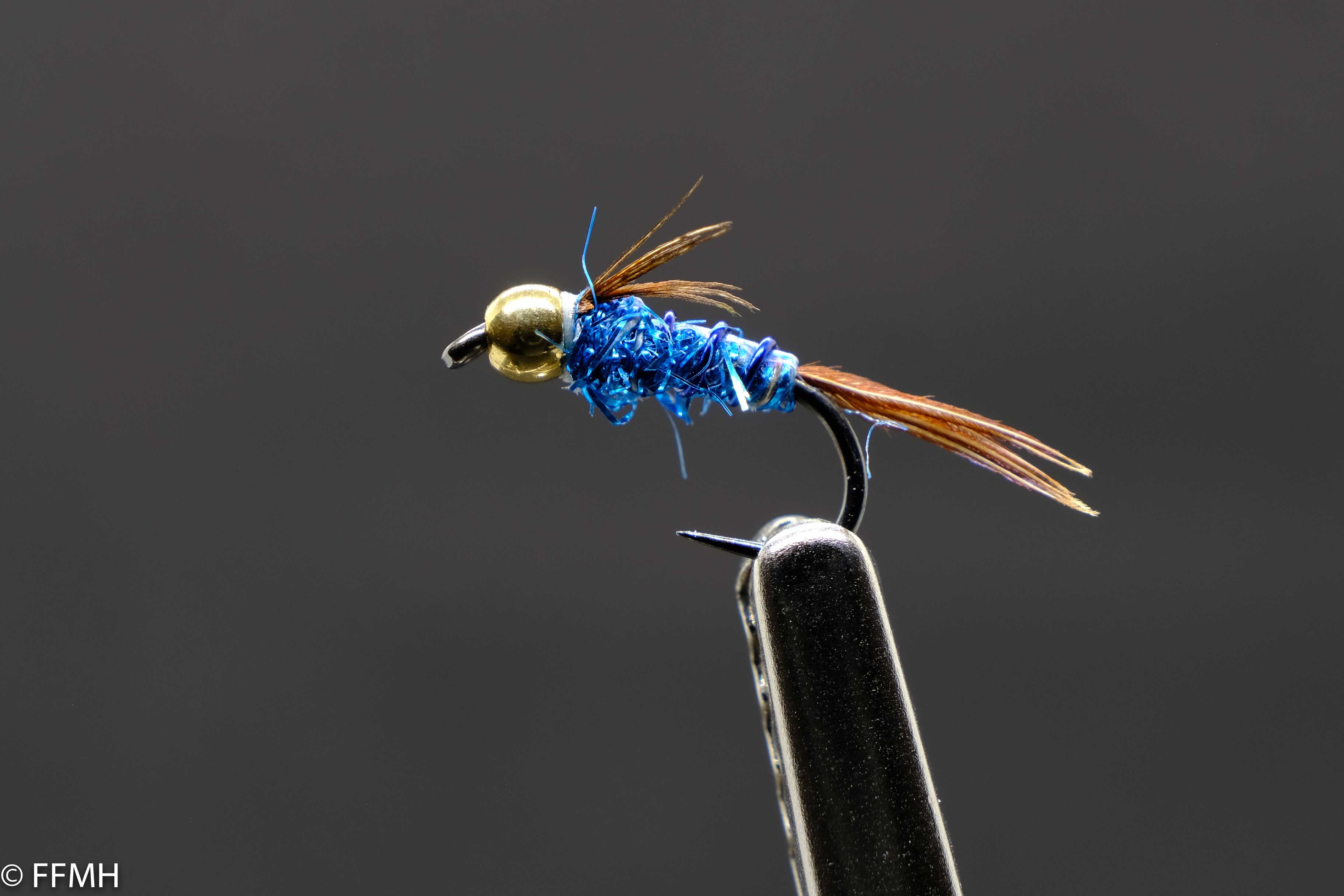 Pheasant Tail Nymph Attractor – moderne Nymphe mit glänzend blauem Körper, goldfarbenem Kopf und markantem Fasanenschwanz, ideal als Reizköder bei trübem Wasser und aktiven Forellen