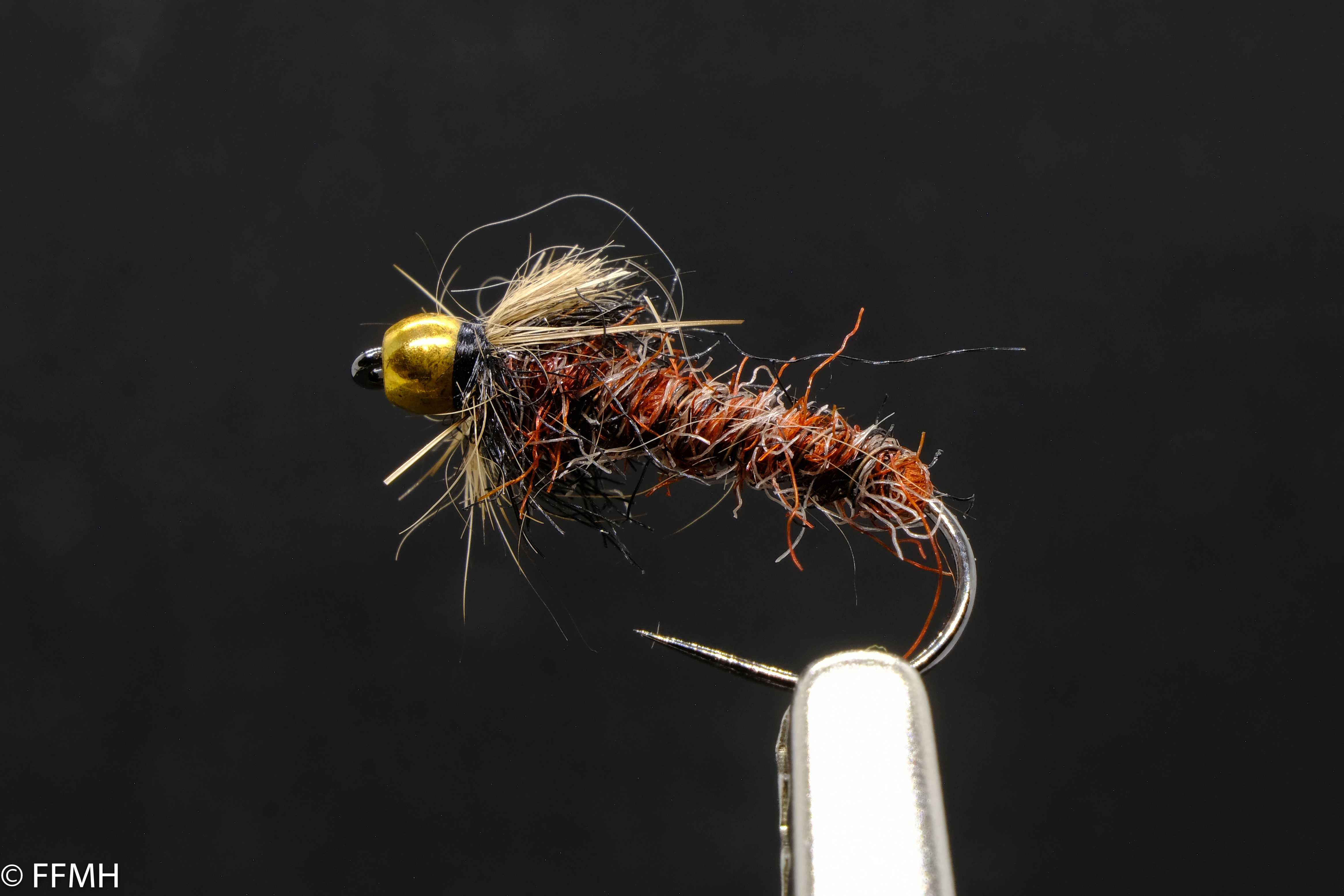 Gold Head Hairy Brown Red Black – handgebundene Nymphe mit goldfarbenem Kopf, dichtem braun-rotem Körper und dunklem Schimmer, ideal für tiefe Gewässerbereiche und selektive Fische