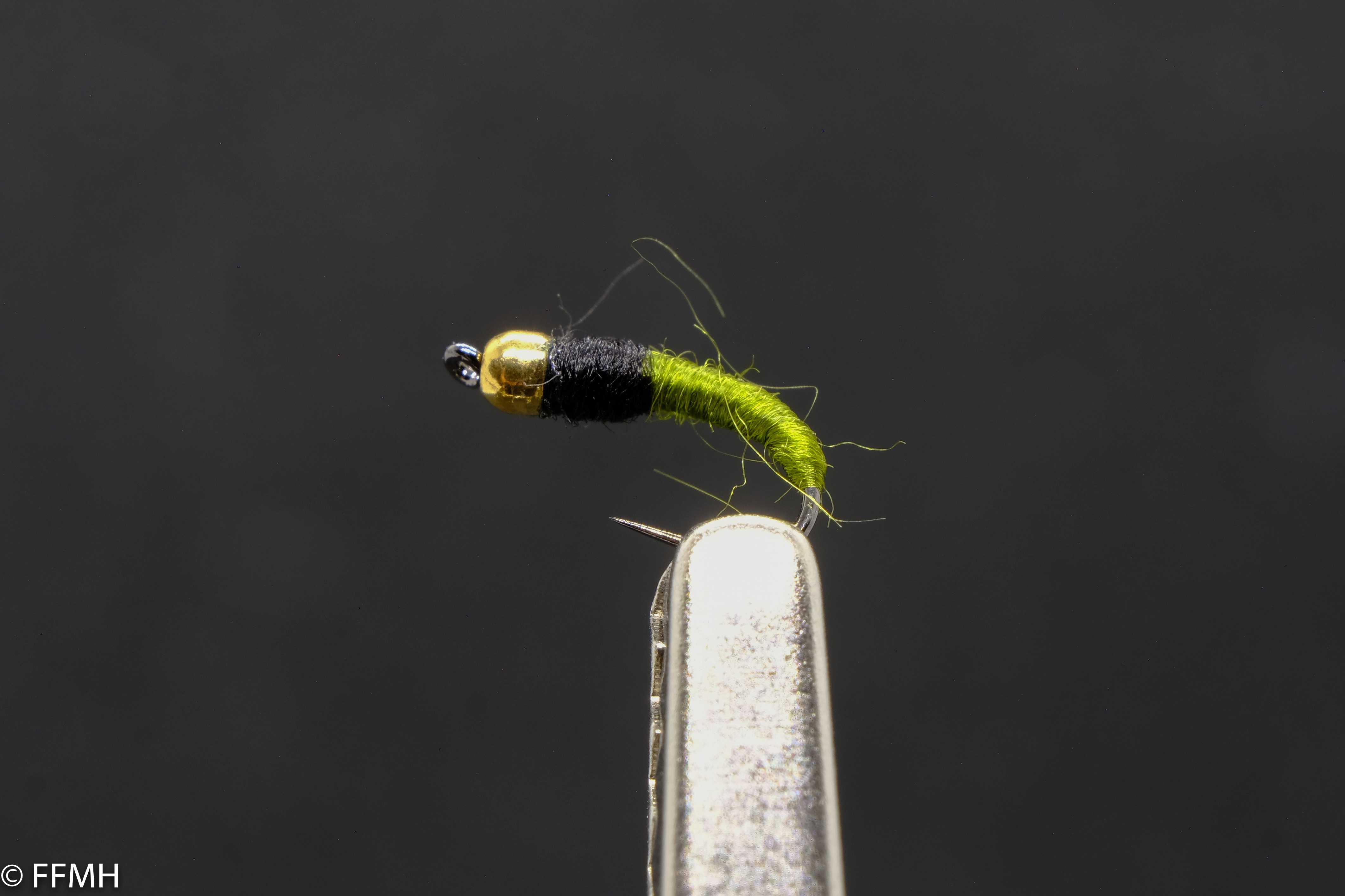 Gold Head Black Green Body – handgebundene Nymphe mit glänzendem Goldkopf, schwarzem Brustbereich und signalgrünem Körper, liebevoll gestaltet für effektives Fliegenfischen in bewegtem Wasser