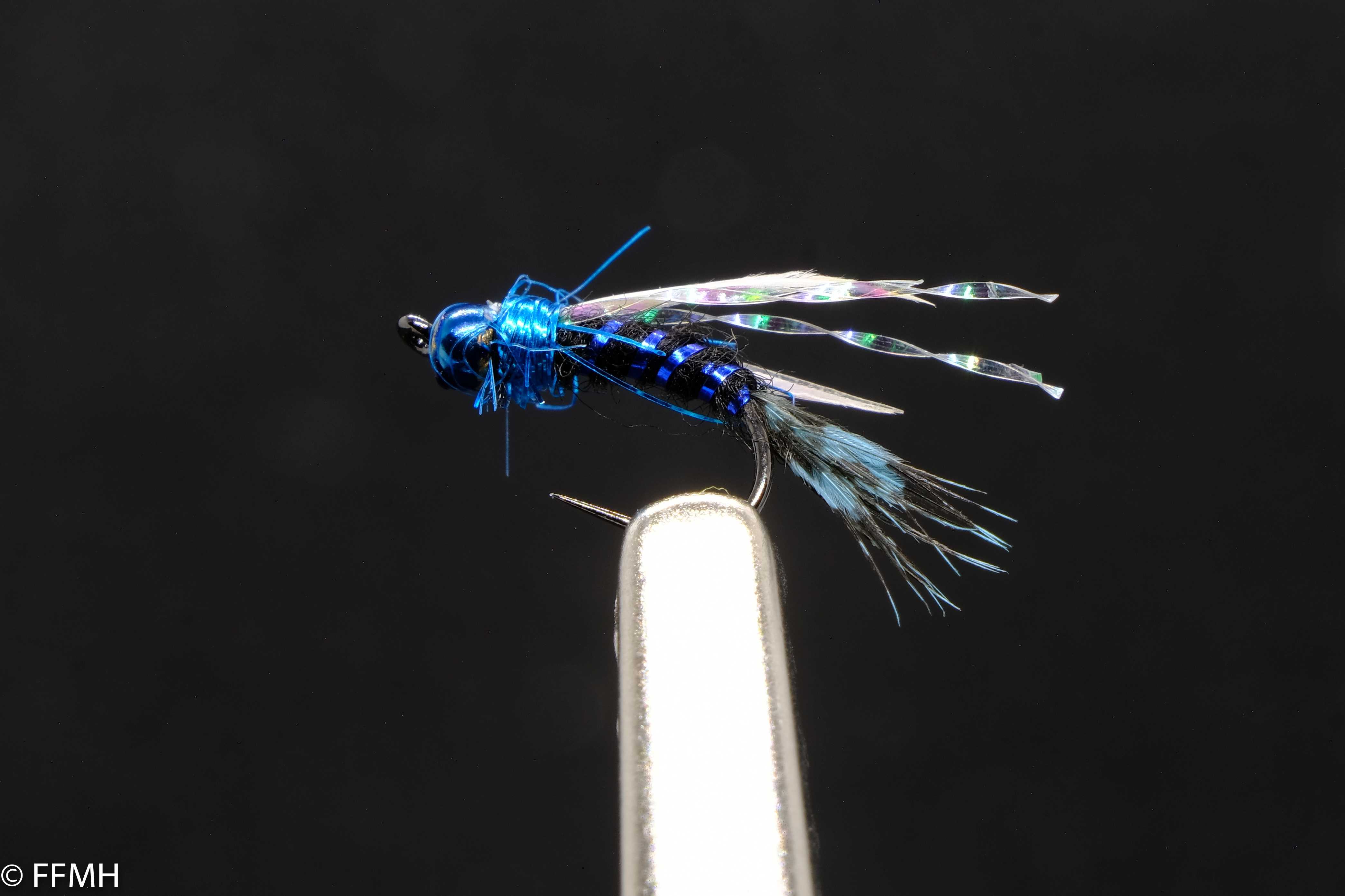 Blue Nymph – auffällig gebundene Nymphe in leuchtendem Blau mit funkelnden Akzenten und langer Schwanzfeder, ideal für aktive Fischerei in klaren Gewässern