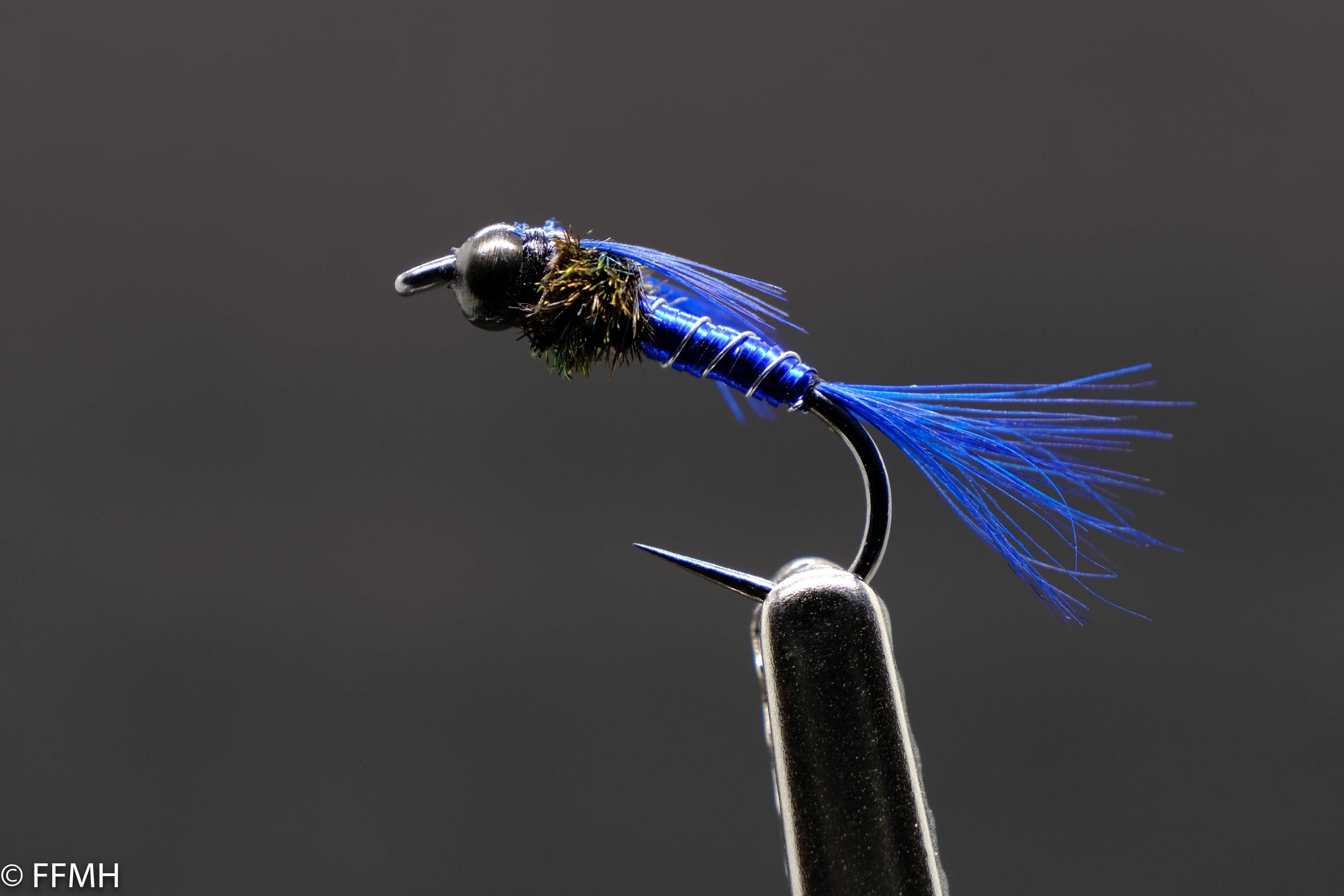 Mahalo Nymph – moderne Reiznymphe mit schwarzem Kopf, schimmernd blauem Körper und kräftigem Schwänzchen, handgebunden für aktive Forellen in tieferem Wasser