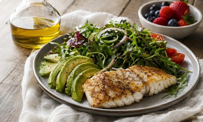 Fish, avocado, vegetables and berries arranged as a meal