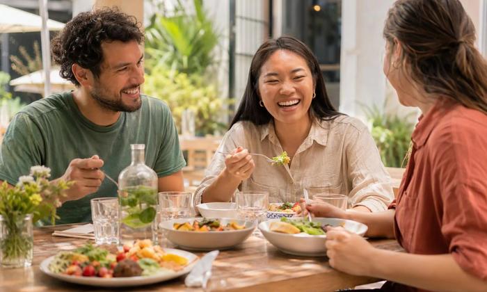Friends sharing a relaxed weekend lunch at an outdoor cafe.