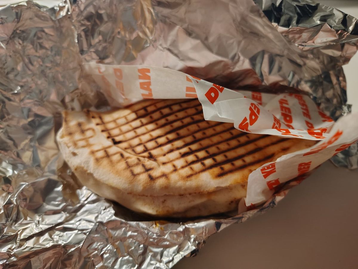 Semi-circle kebab wrapped in tinfoil and paper