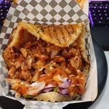 A packed pita sandwhich with juicy chicken and sauce